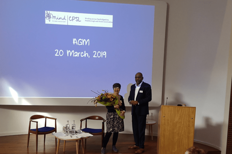 A black man and white woman holding flowers at the 2019 AGM