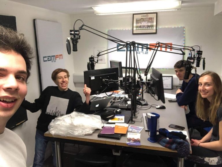 A group of men and a woman in the Cam FM radio studio