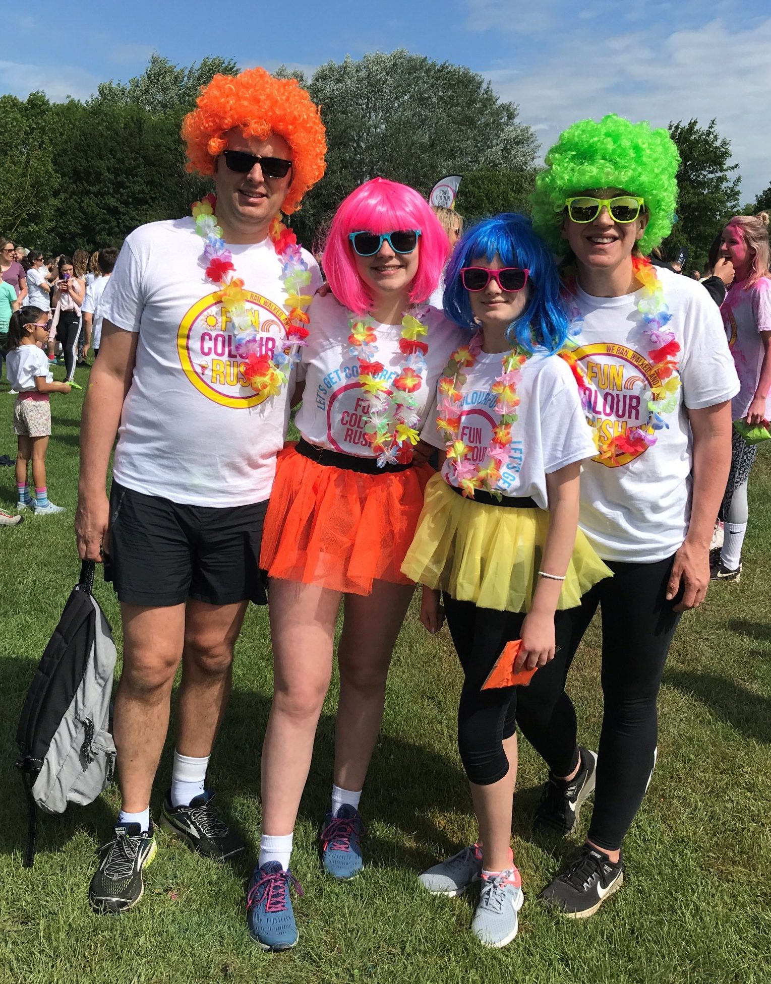 Group of people with colourful wigs and sunglasses on with fun colour rush tshirts on