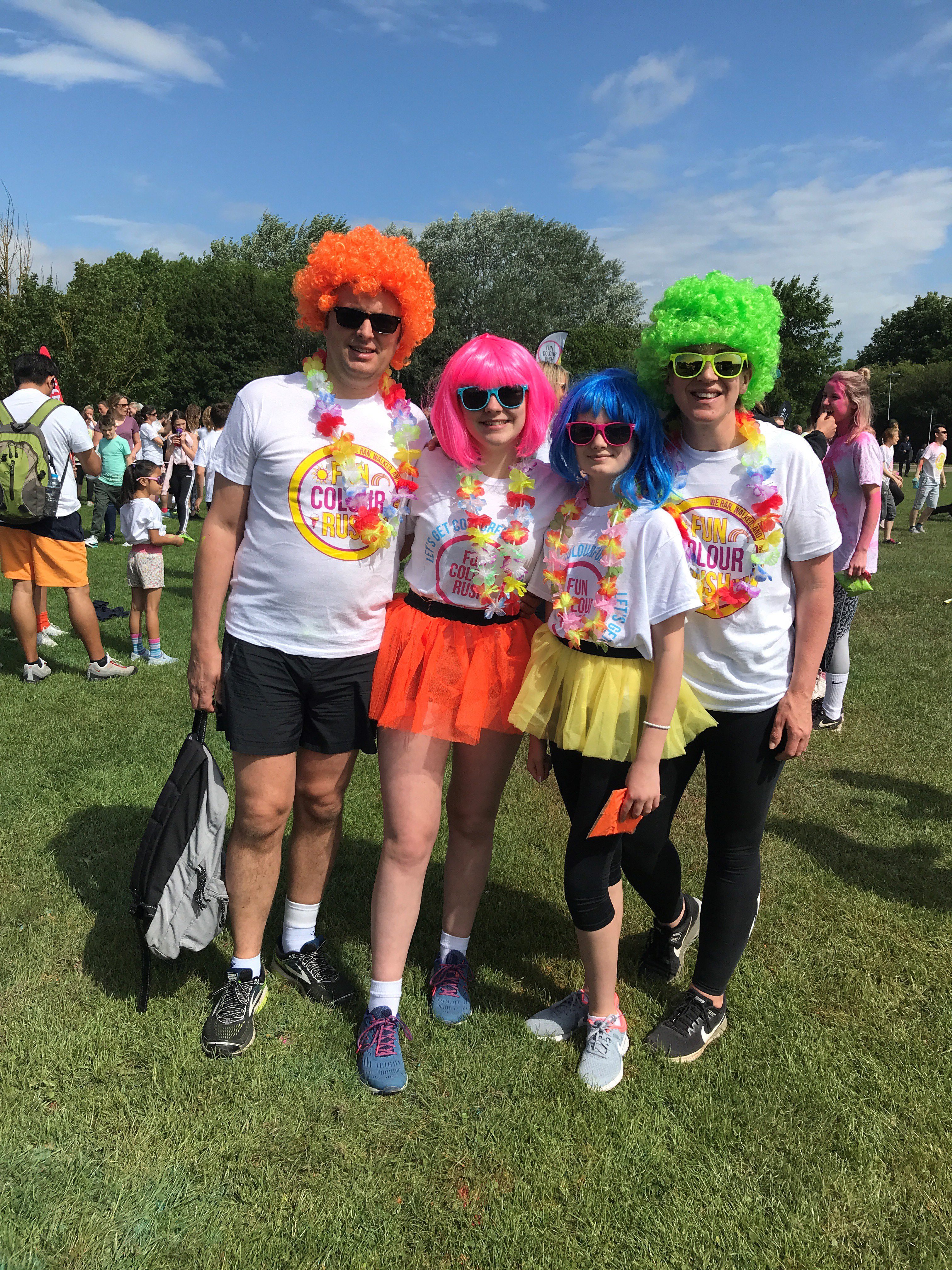 Group of people with colourful wigs and sunglasses on with fun colour rush tshirts on