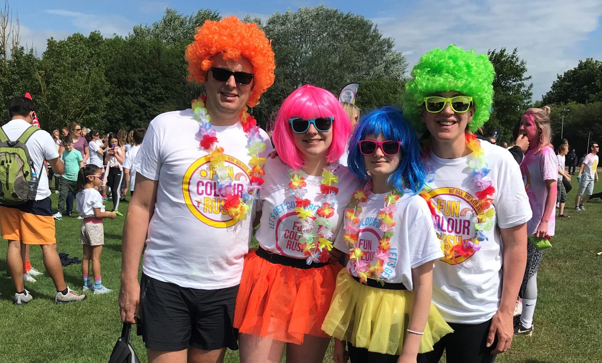 Group of people with colourful wigs and sunglasses on with fun colour rush tshirts on