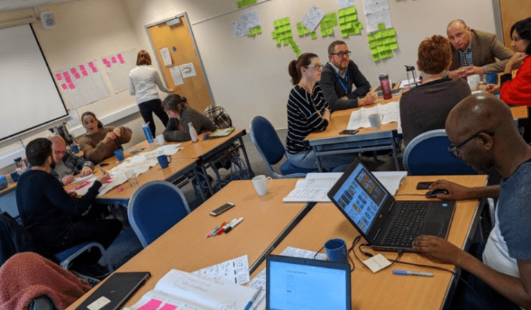 A group of people sat at three different tables having a training session