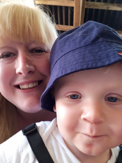 A blonde woman and child with a blue hat on