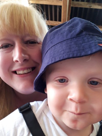 A blonde woman and child with a blue hat on