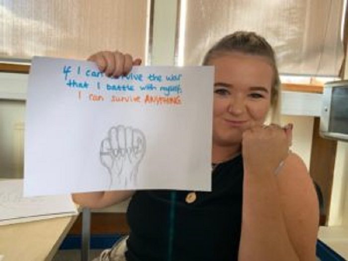 Blonde girl holding a sign which says If I can survive the war that I battle with myself I can survive anything