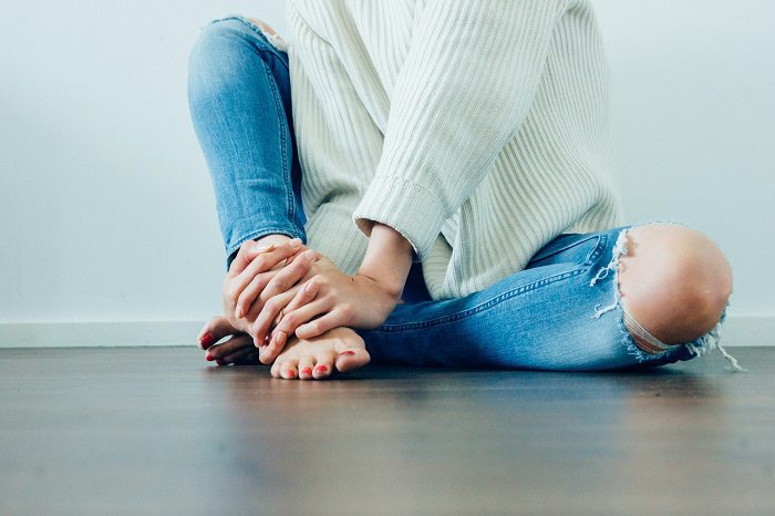 A woman sitting on the floor with her legs crossed