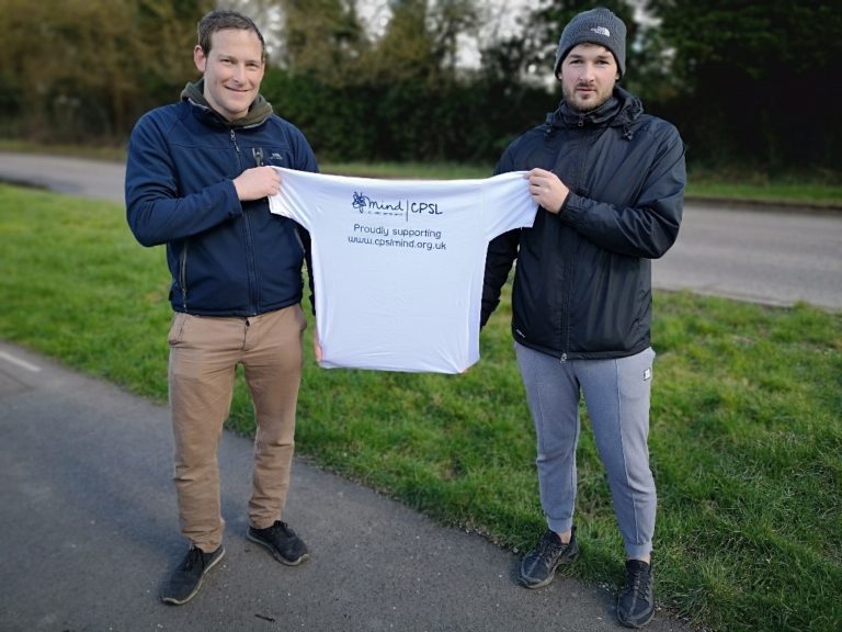 Two men outside holding a white CPSL Mind tshirt