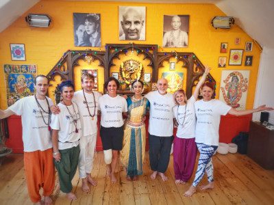 A group of people in CPSL Mind t shirts smiling at the camera in a yellow yoga studio