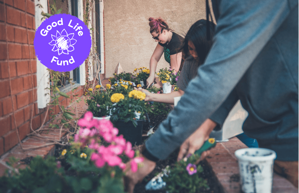 Three people digging the mud to plant flowers in the garden