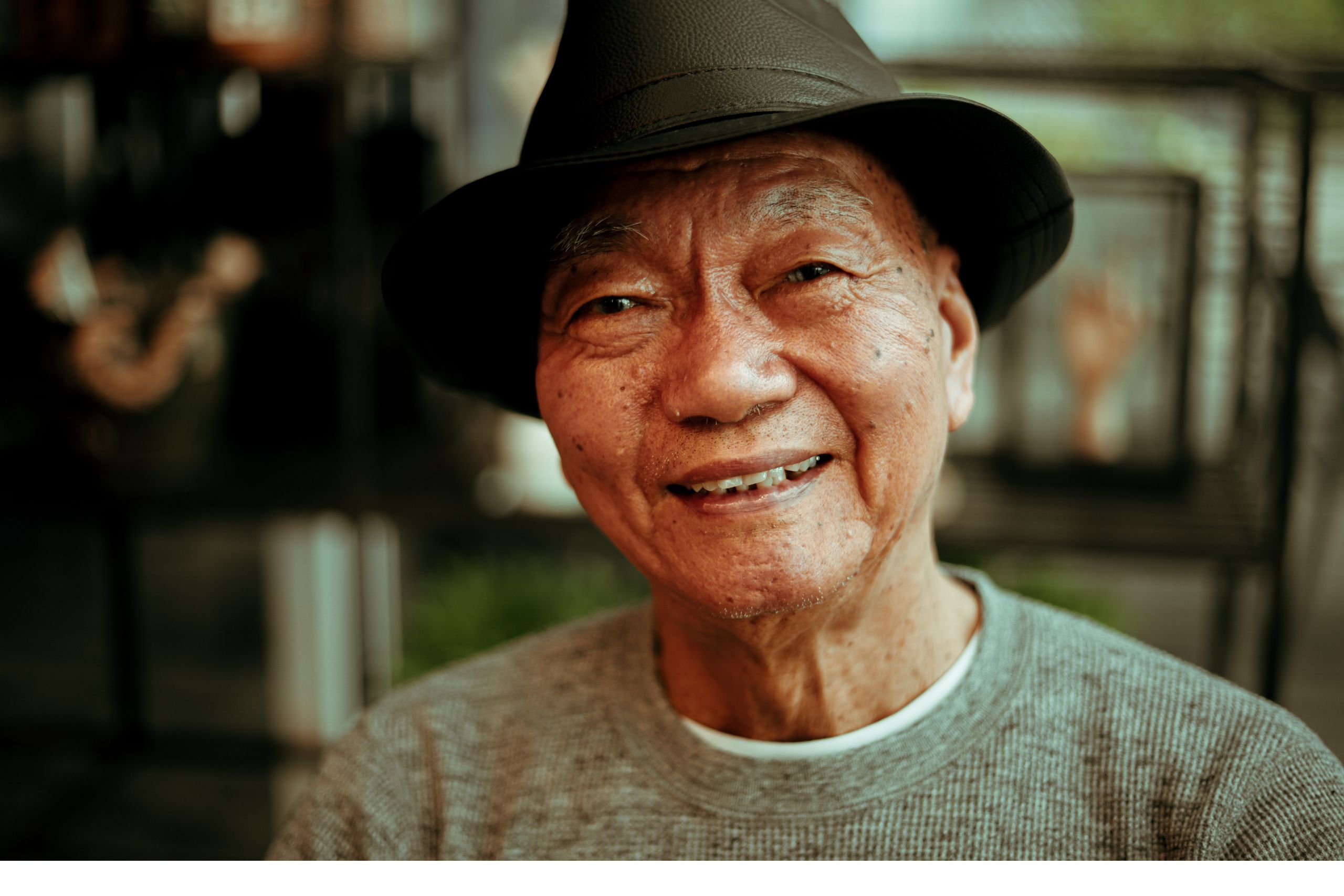 Senior man smiling at the camera with a black hat on