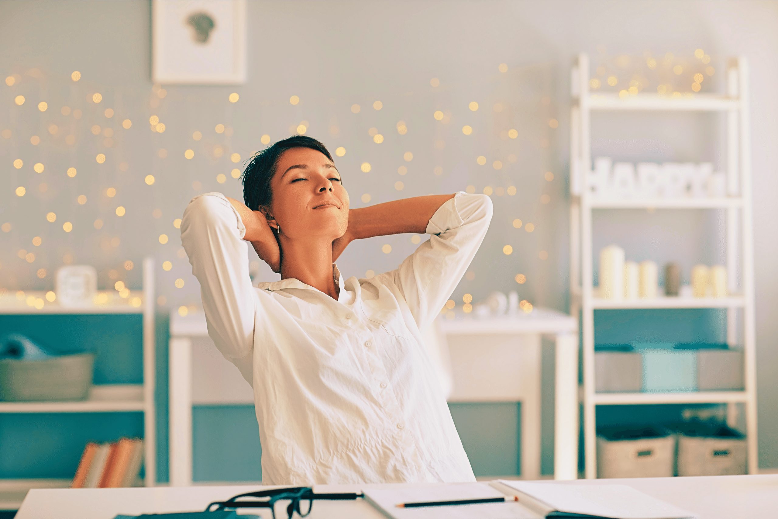 Woman in home office leaning back on her chair with her hands behind her head looking relaxed