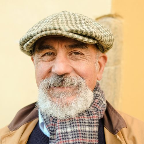 Senior man in hat smiling with scarf