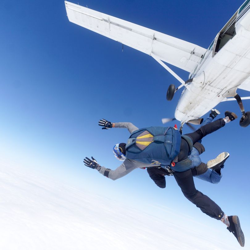 A man jumping from a plane for a skydive