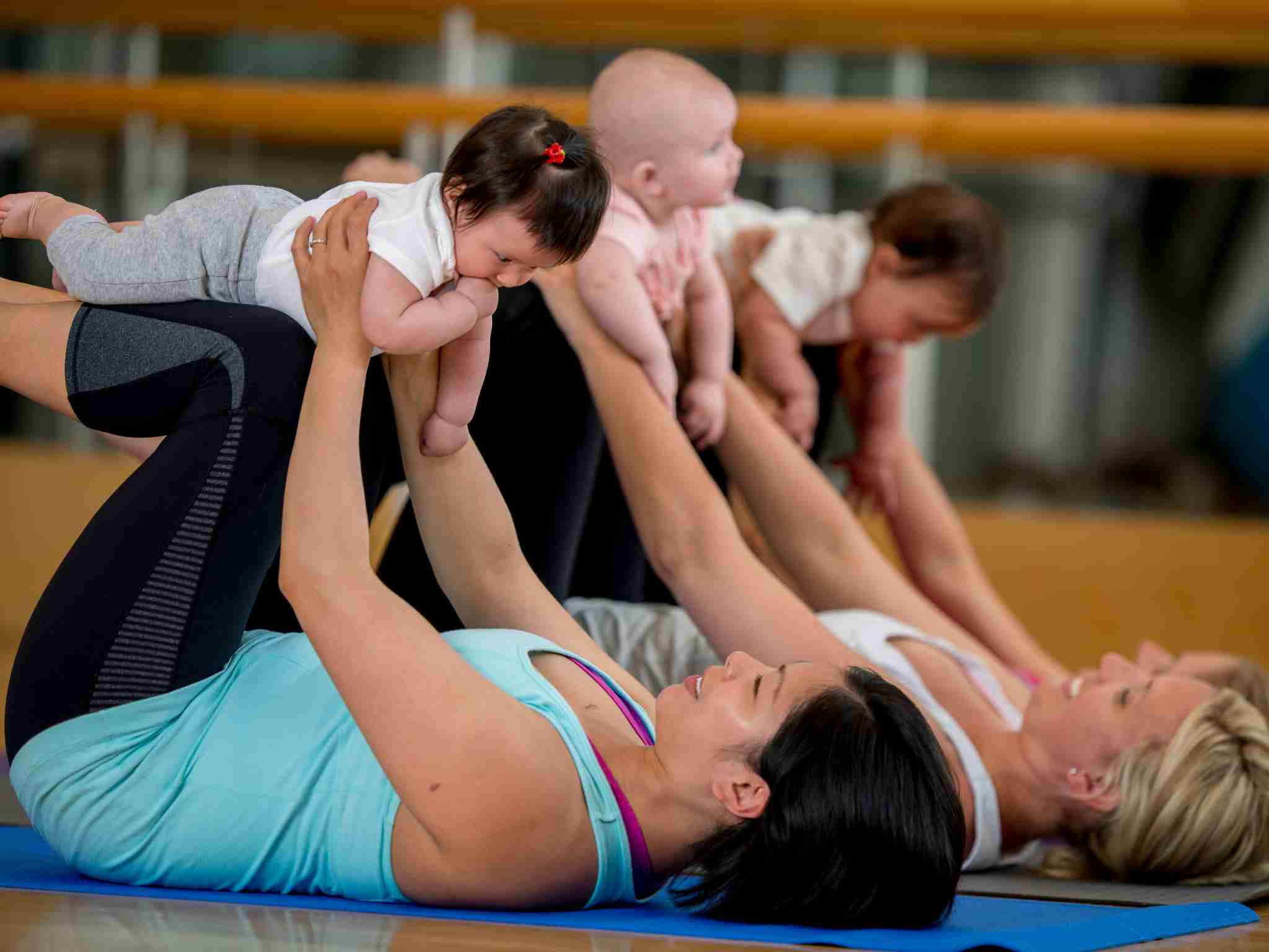 Three mothers doing yoga with their babies
