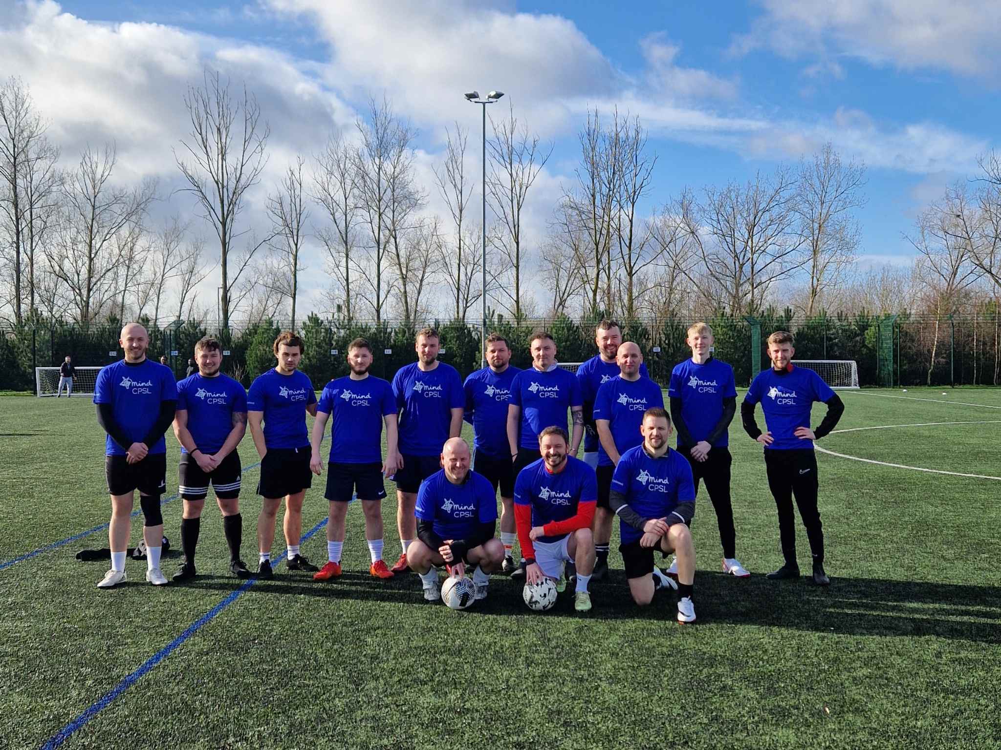 Football players in CPSL Mind t-shirts standing on football pitch