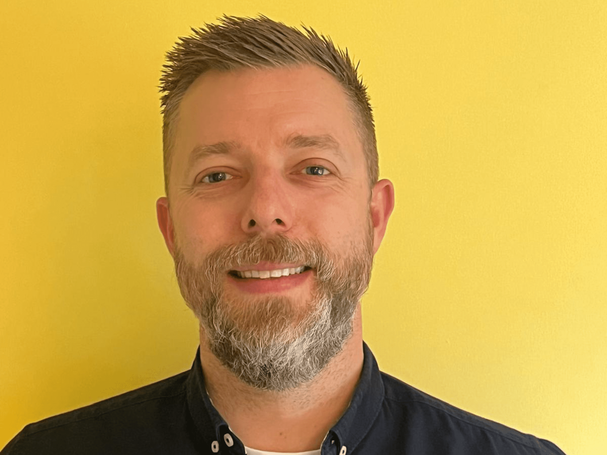 Ashley Bunn smiling against a yellow background