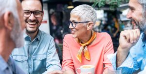 Group of people sitting around a table in a coffee shop