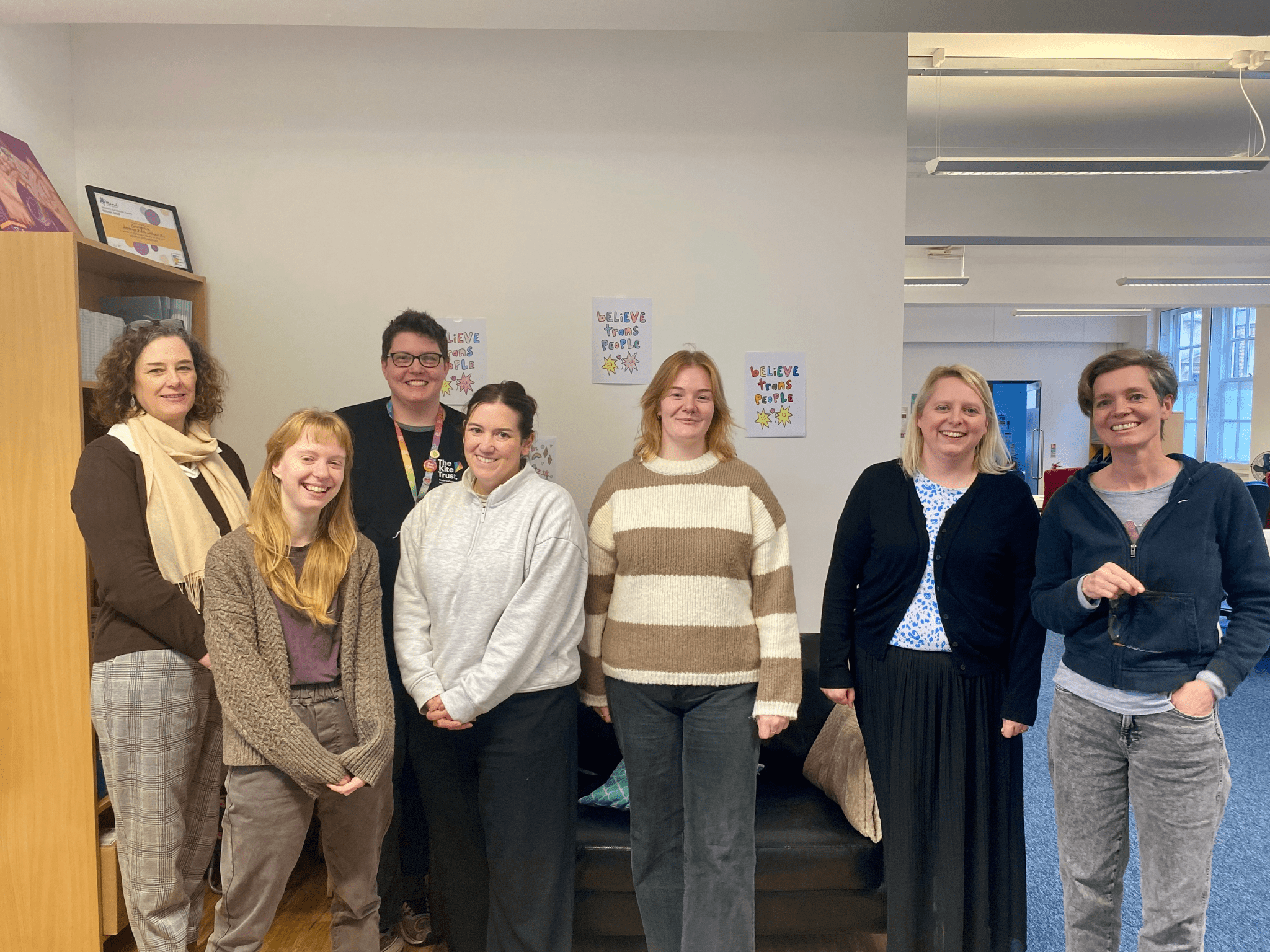group of people in a group, in an office smiling