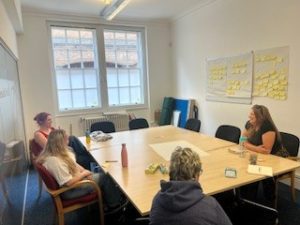 group of people sitting around a table in a boardroom 