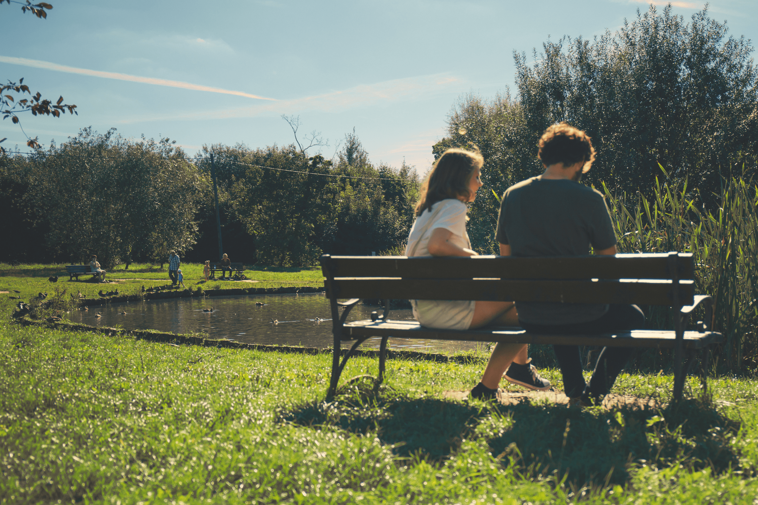 man and woman sitting on bench