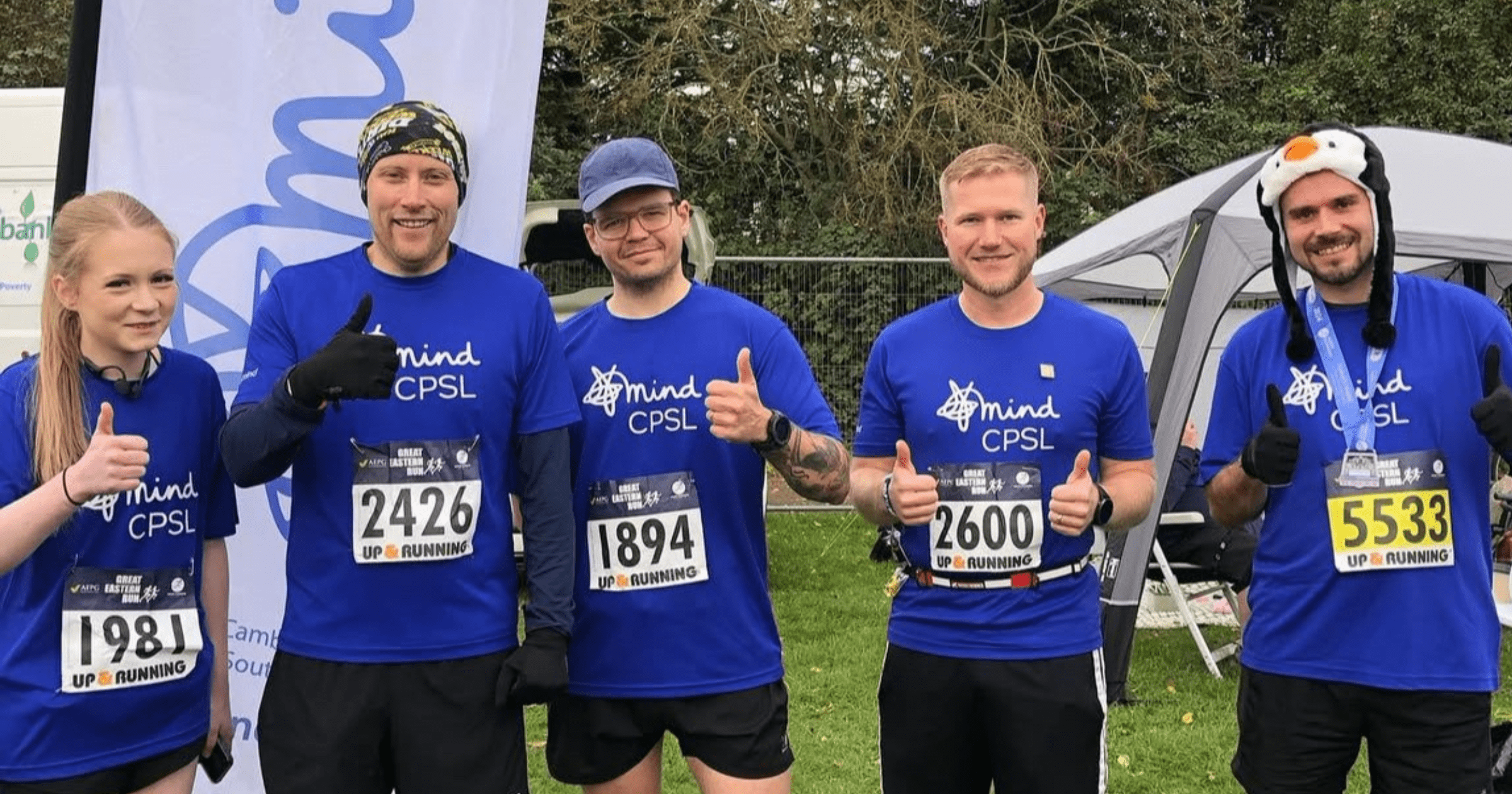 runners wearing blue t-shirts smiling at the camera