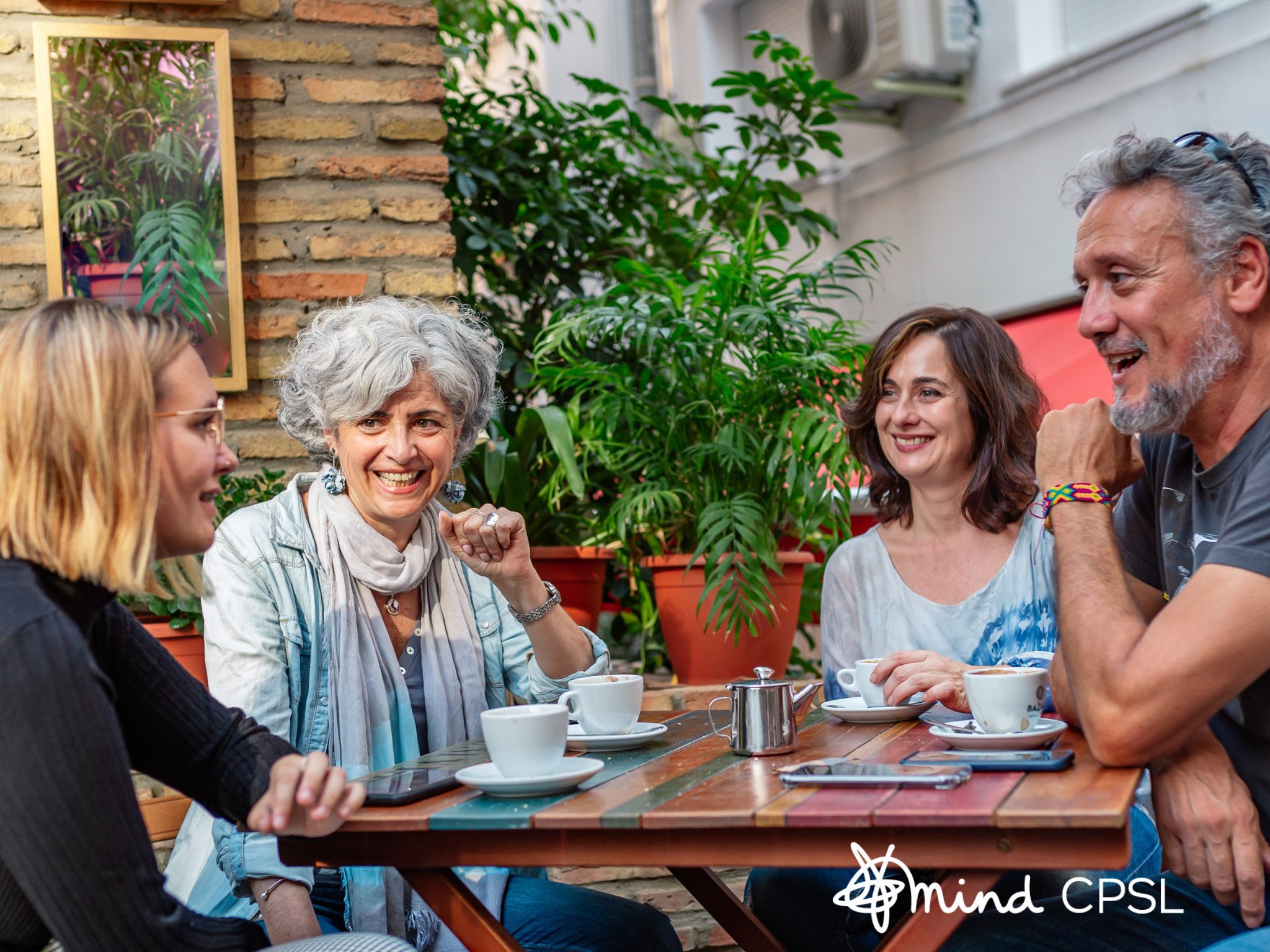 group of people talking around a table with coffee cups