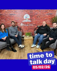 group of three men and one woman on blue shirt sitting on sofa with mics 