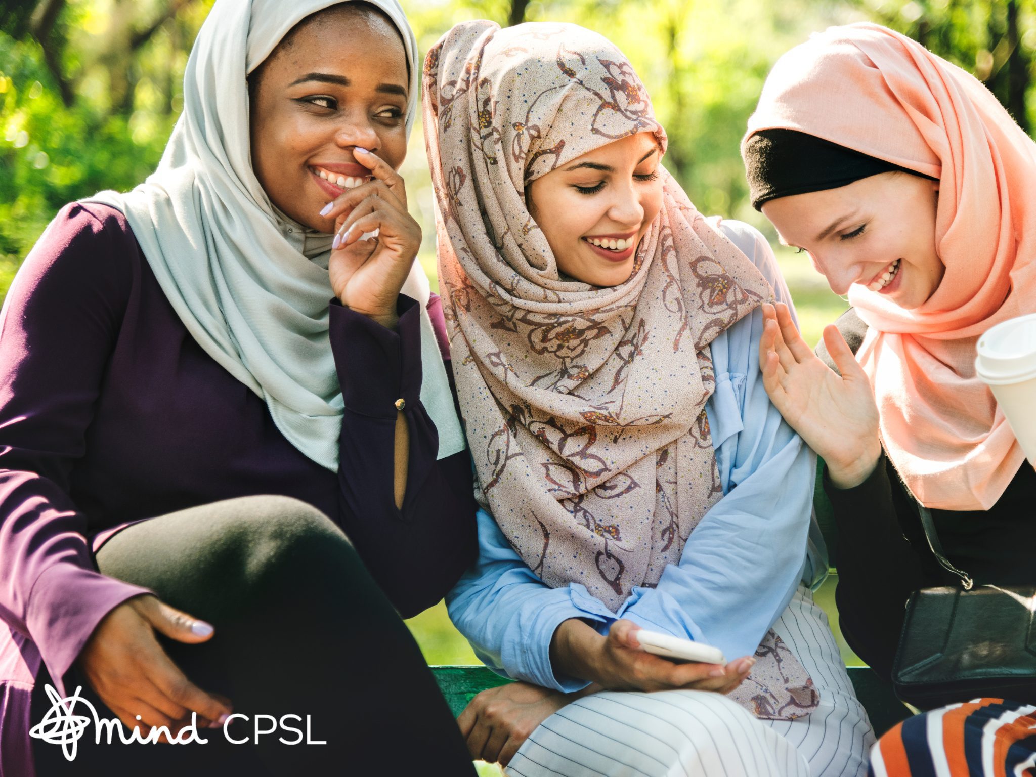 three women smiling wearing headscarves