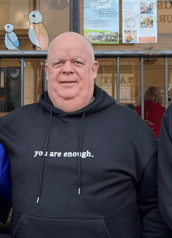 man wearing black hoody smiling